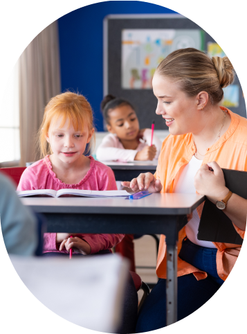 Lehrerin hilft einer Schülerin am Tisch